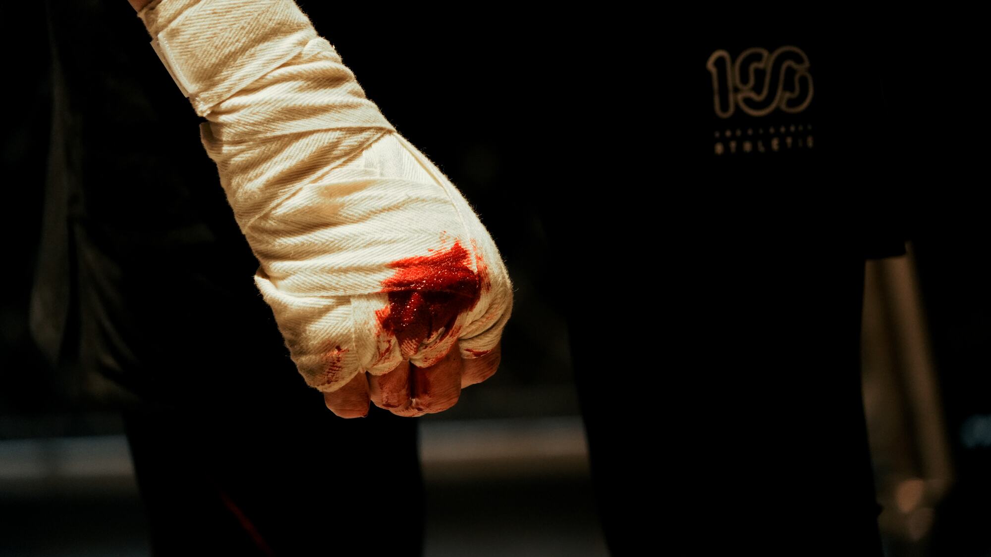A taped fist, stained with blood
